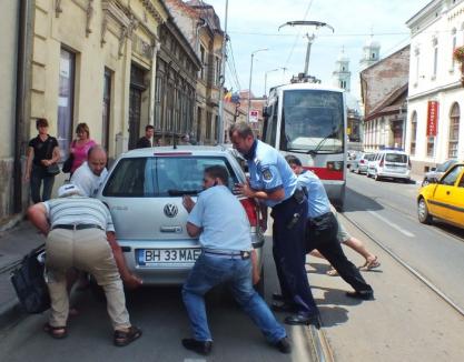 Ajutaţi de trecători, doi poliţişti au ridicat cu mâinile o maşină ce bloca tramvaiele pe Primăriei (FOTO)